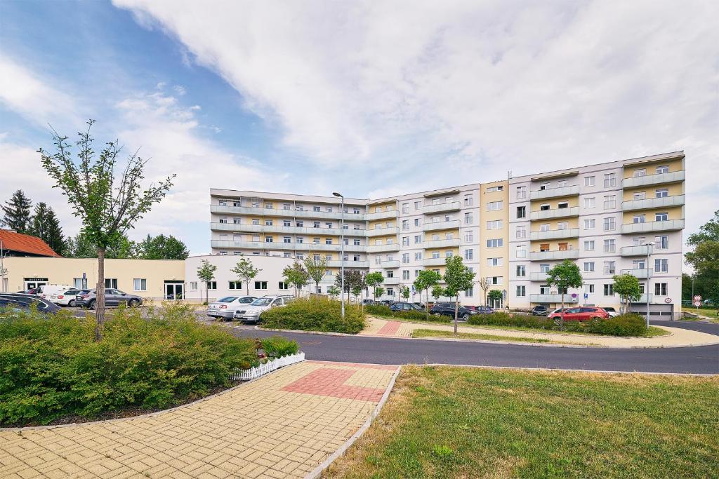 a large apartment building with cars parked in a parking lot at Apartman Residence Moser 1504 in Karlovy Vary
