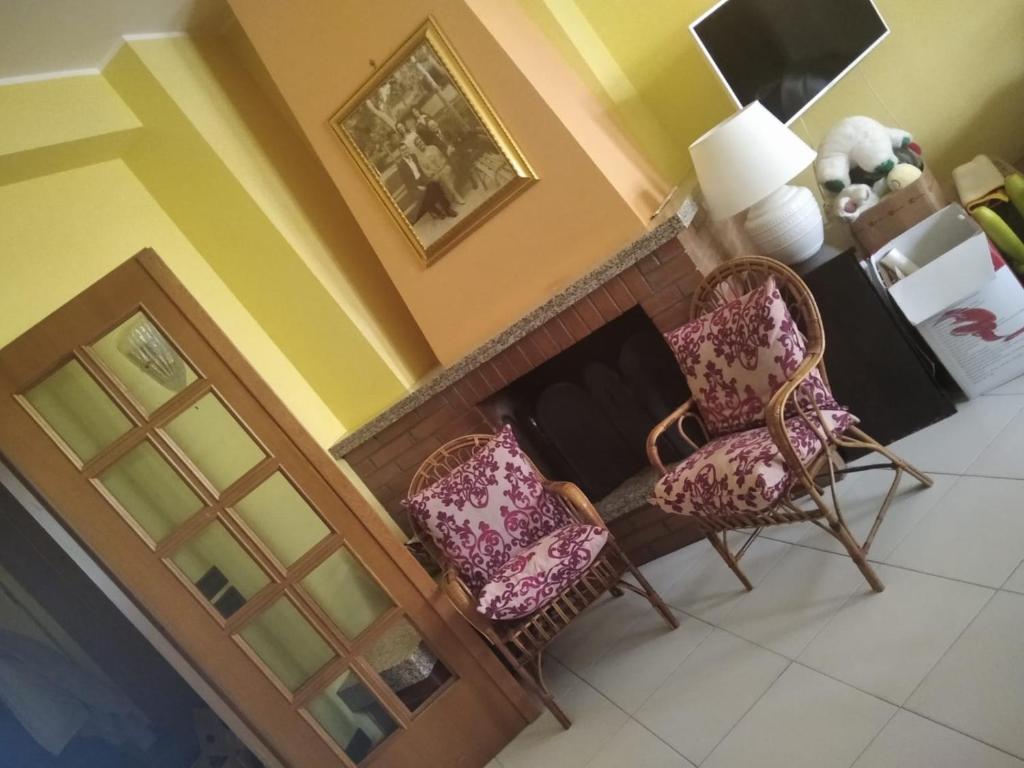 ein Wohnzimmer mit 2 Stühlen und einem Kamin in der Unterkunft Casa Carlo&Luisa in Pescara