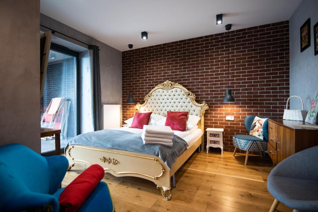 a bedroom with a bed with a brick wall at City Lights Kazimierz in Krakow