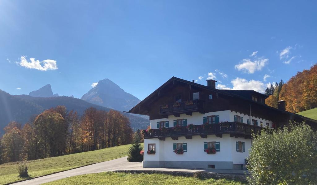 una casa en una colina con montañas en el fondo en Oberstöberl, en Bischofswiesen