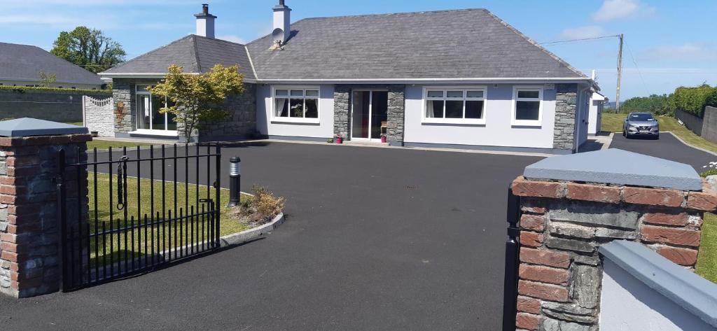 a house with a black gate and a driveway at Green Acres Guesthouse- Accommodation Only in Killarney