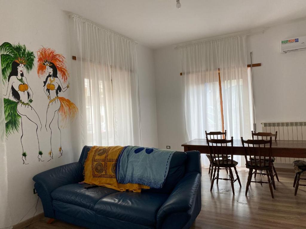 uma sala de estar com um sofá azul e uma mesa em La casa di Gianfry em Paola