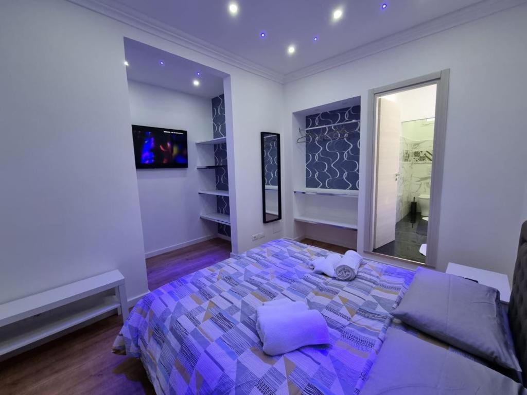 a bedroom with a bed with purple sheets and a mirror at Piazza Colombo-Apartments in Sanremo