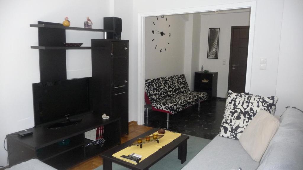 ein Wohnzimmer mit einem Sofa und einem TV in der Unterkunft D&J Central Appartment in Ioannina