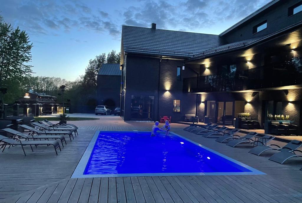 um par de pessoas em pé em uma piscina em SKY Villa em Palanga