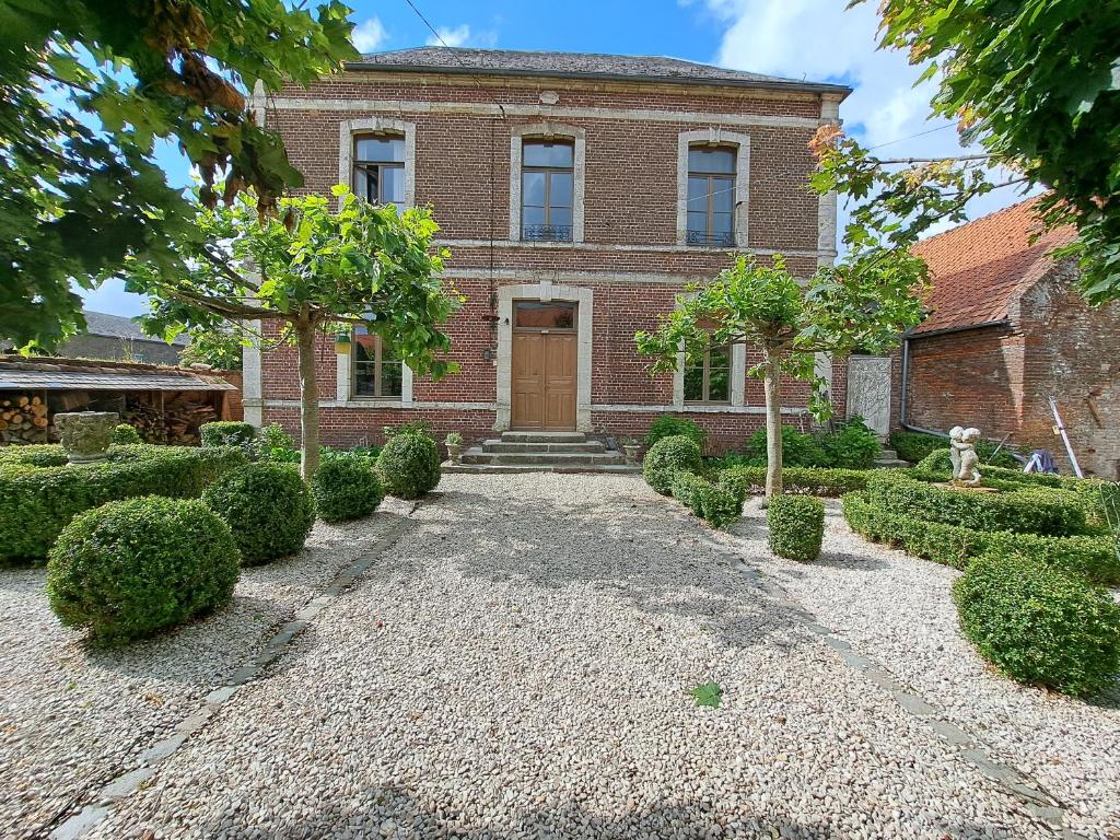 Aubencheul-aux-Bois的住宿－Maison de vacances à la campagne avec piscine "MAISON SIMON"，砖屋,有门和庭院