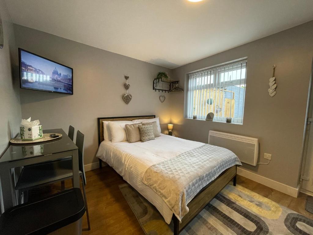 a bedroom with a bed and a tv on the wall at Westend Holiday Let 4 Brecon in Brecon