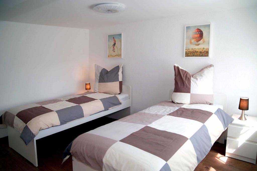 オーバールングヴィッツにあるFeWo -schiefe- Marieのベッドルーム(ベッド2台、ランプ2つ付)