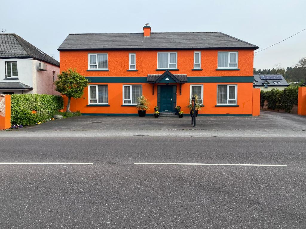 an orange house with a green door on a street at Ros Villa Guesthouse in Killarney