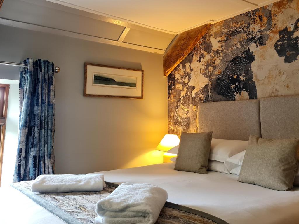 a bedroom with a bed and a painting on the wall at Furzeleigh Mill in Buckfastleigh