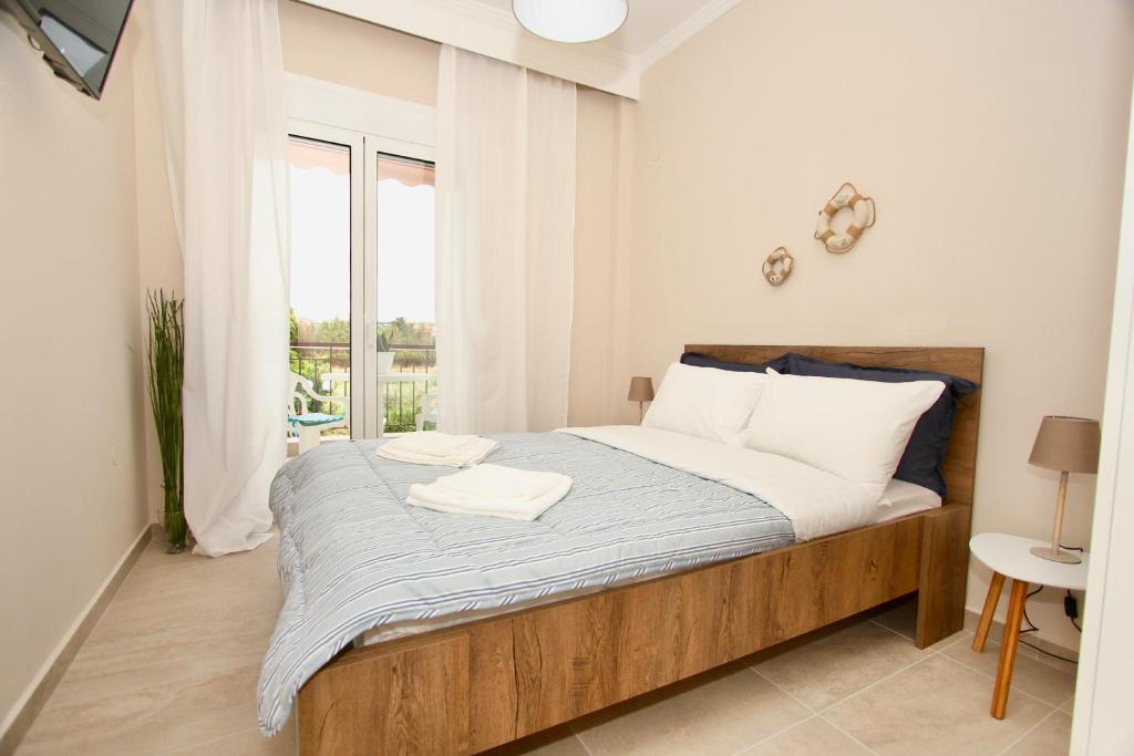 a bedroom with a large bed with a window at Lovely apartment by the sea..... in Epanomi