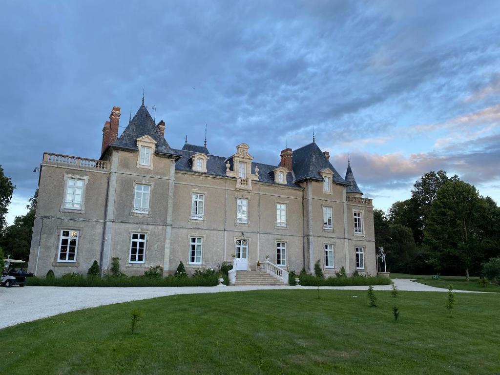 a large castle with a grassy yard in front of it at Château de St-fulgent, gîte La Tour in Saint-Fulgent