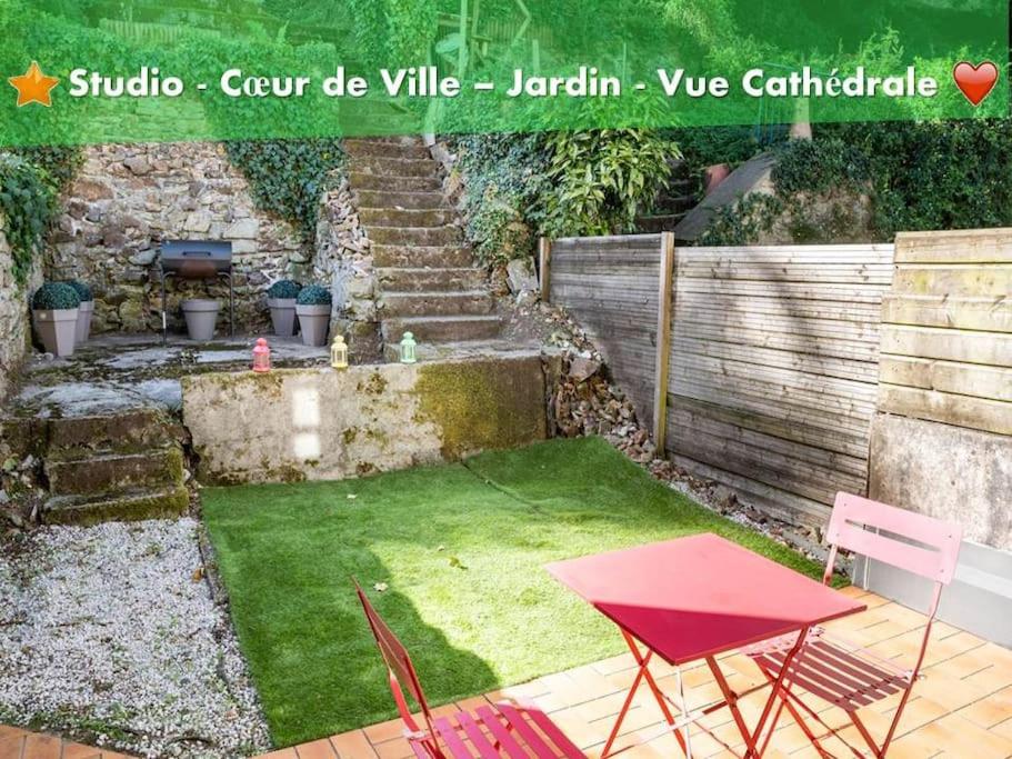 een kleine tuin met een rode tafel en stoelen bij oo Le jardin oo paisible studio équipé et bien placé in Quimper