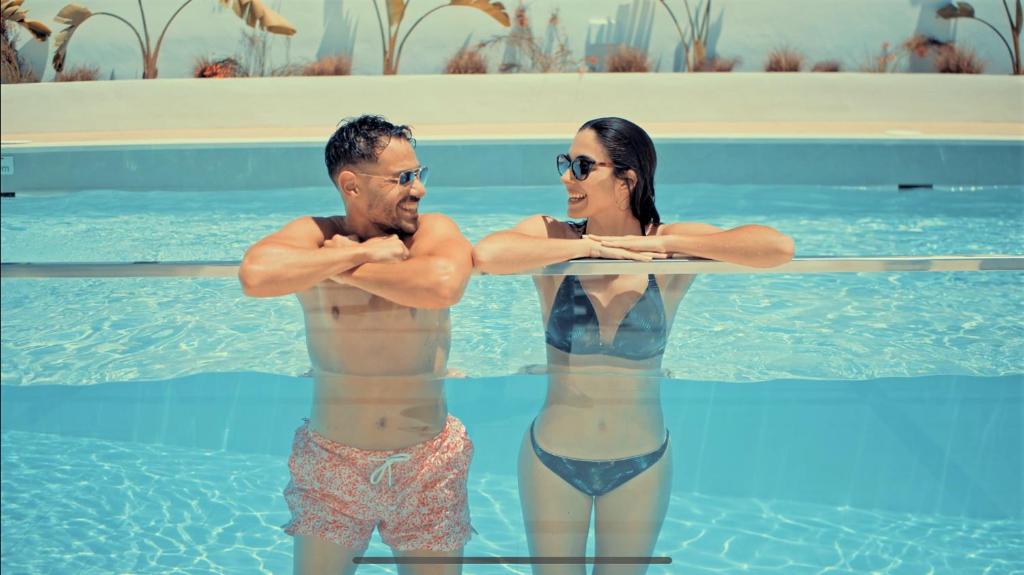 a man and a woman standing in a swimming pool at Caleyro Boutique Apartments - "Parking incluido" in Fuengirola