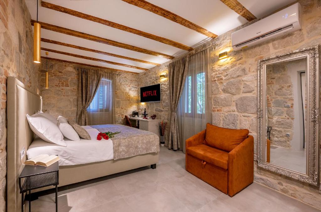 斯普利特的住宿－Old Spalatrum Luxury Rooms，一间卧室配有一张床和一把椅子