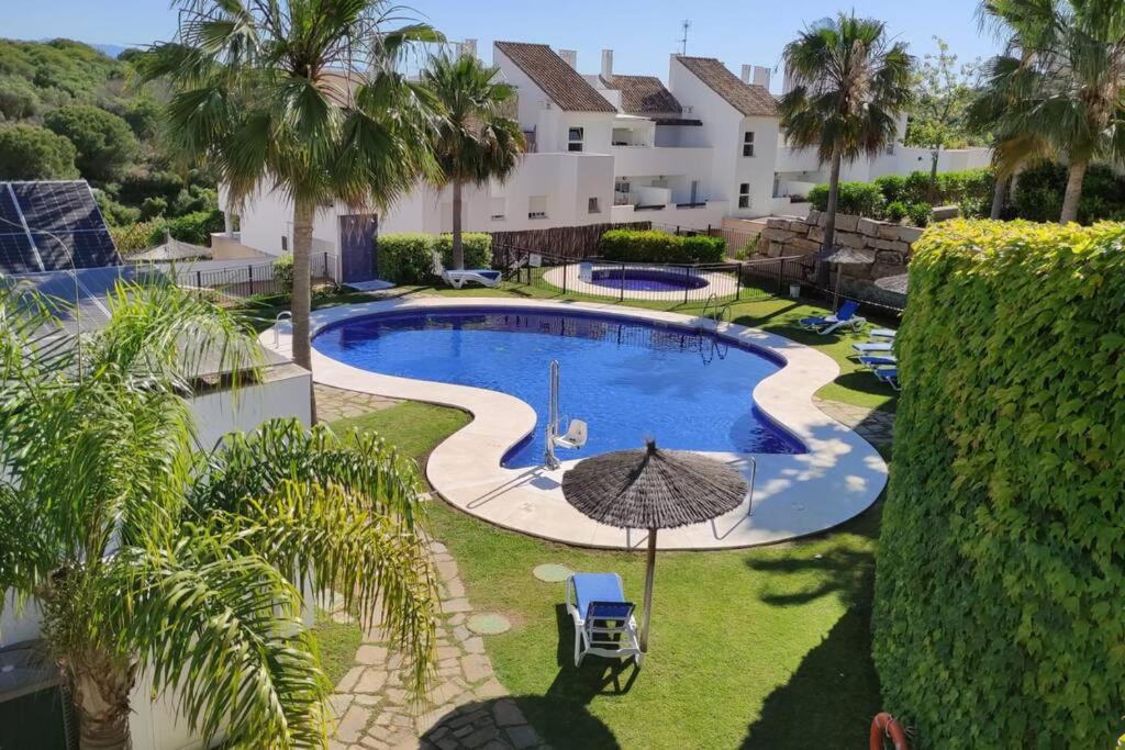 an overhead view of a swimming pool with an umbrella at Precioso Apartamento con vistas al Mar en La Alcaidesa in San Roque