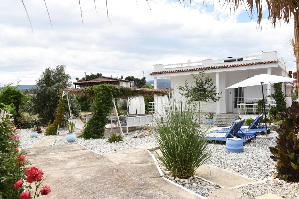 een villa met een zwembad en een huis bij Los Almyros in Míloi