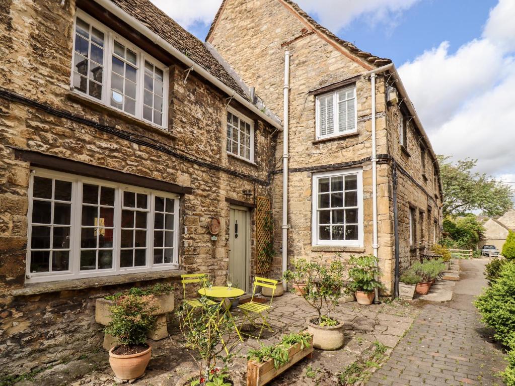 una casa de piedra con patio y plantas frente a ella en 3 George Yard, en Burford