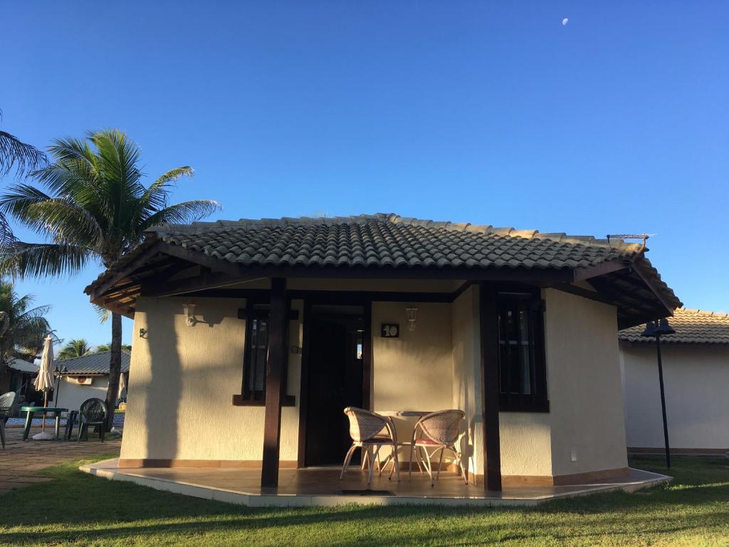 Casa pequeña con 2 sillas y porche en Chalé em frente à Praia, en Salvador