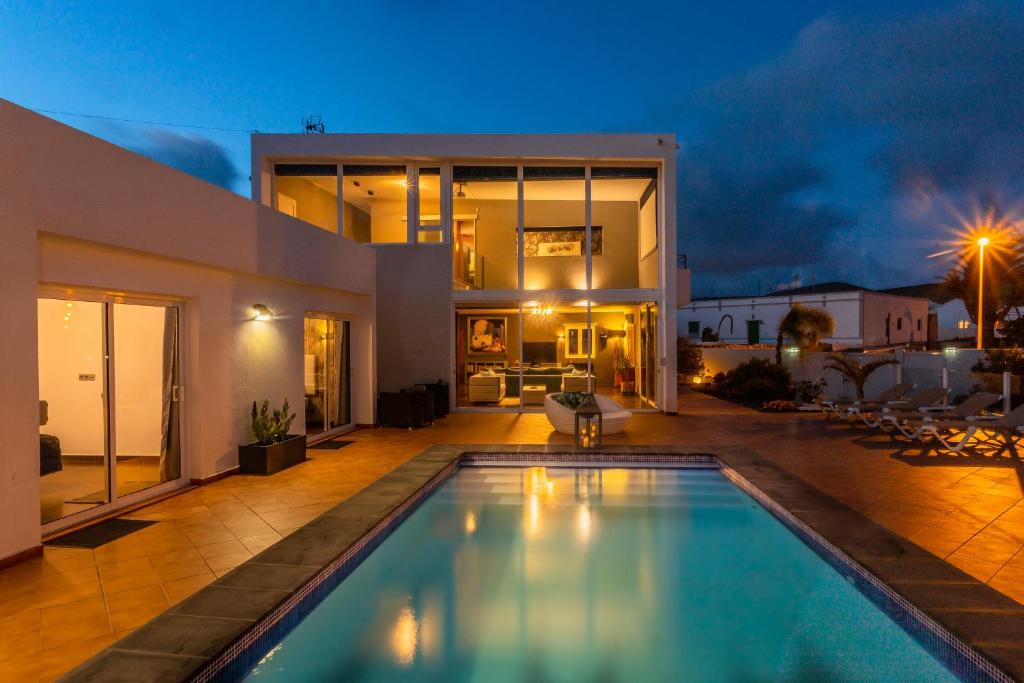 a house with a swimming pool at night at Villa Alma in Tías