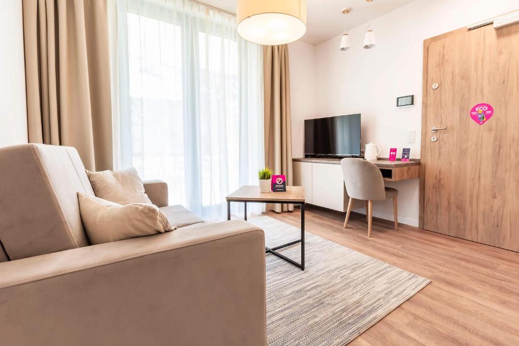 梅爾諾的住宿－VacationClub – Jantaris Apartament A8，带沙发、桌子和电视的客厅