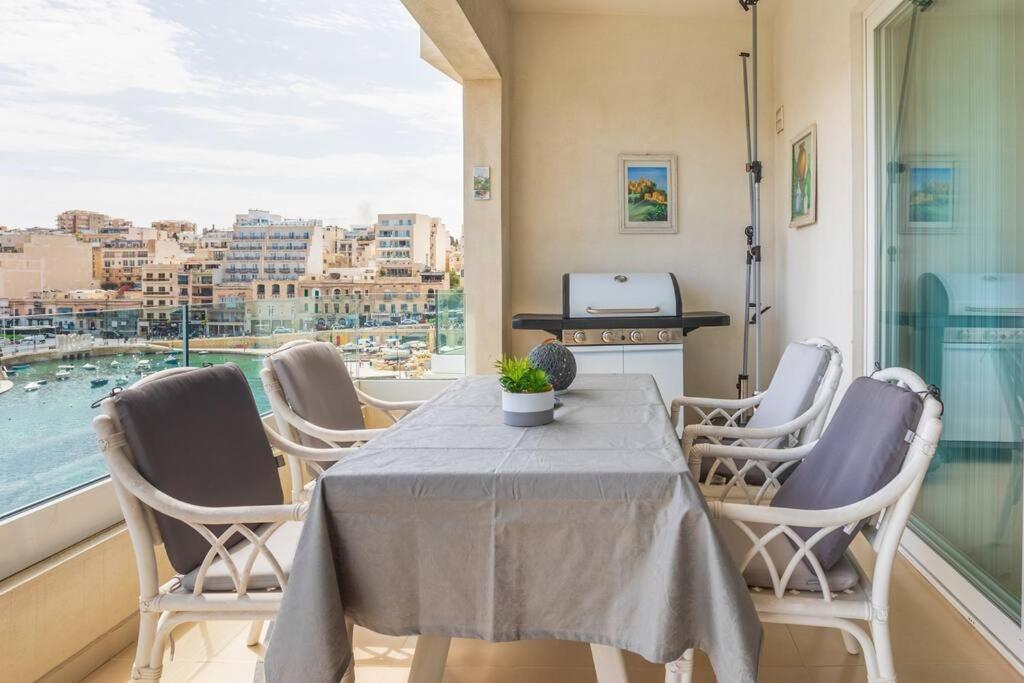 a dining room with a table and chairs and a window at Luxury Seafront 2 bedroom apartment in Spinola Bay in St. Julianʼs