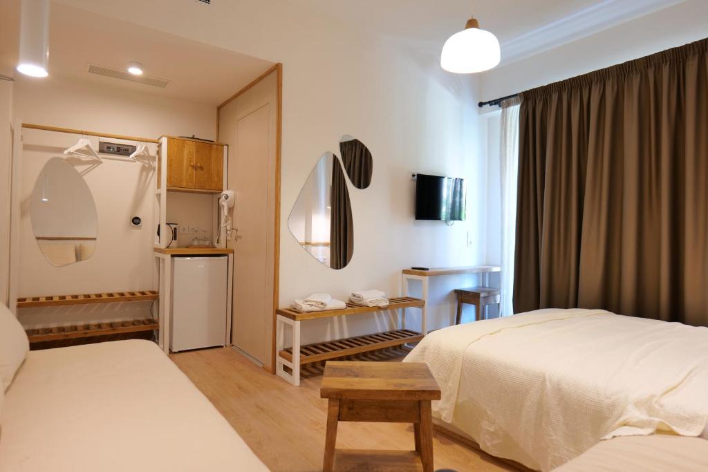 a hotel room with two beds and a refrigerator at Alex & Sofi Apartments in Himare