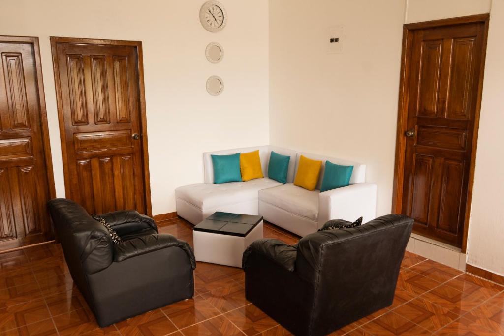 sala de estar con 2 sillas y sofá en RinaKawsay - ViveViajando HERMOSO Penthouse completamente amoblado en TENA, en Tena