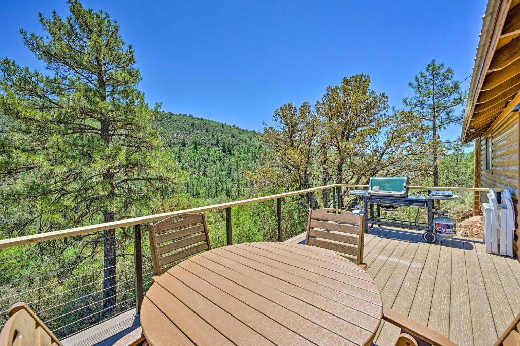 a wooden deck with a table and a laptop on it at Payson Cabin with Deck Views of the Mogollon Rim! in Payson