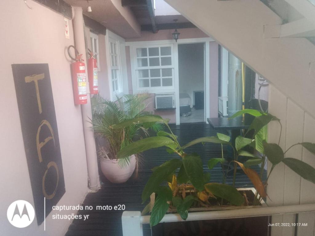 a porch with potted plants in a house at Tao in Búzios