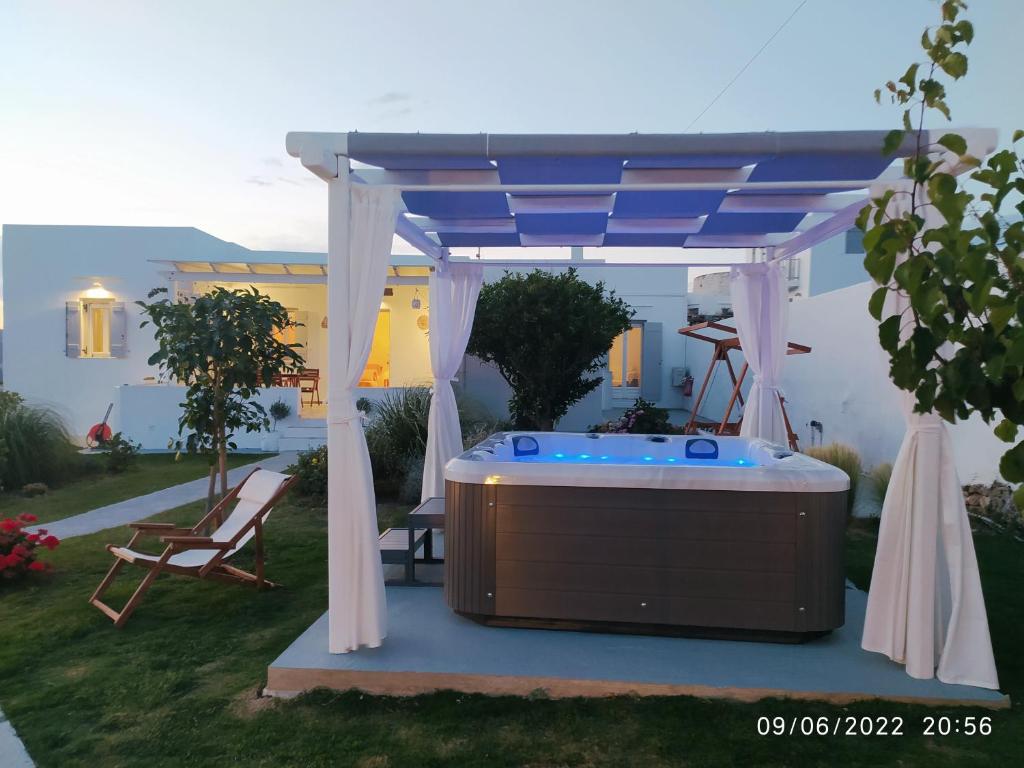 a hot tub under a gazebo in a backyard at GeoNi's villa & garden spa in Apollonia