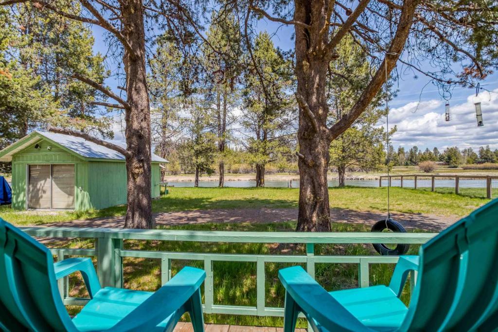 a picnic table with chairs and a shed at Riverside Breeze in Bend