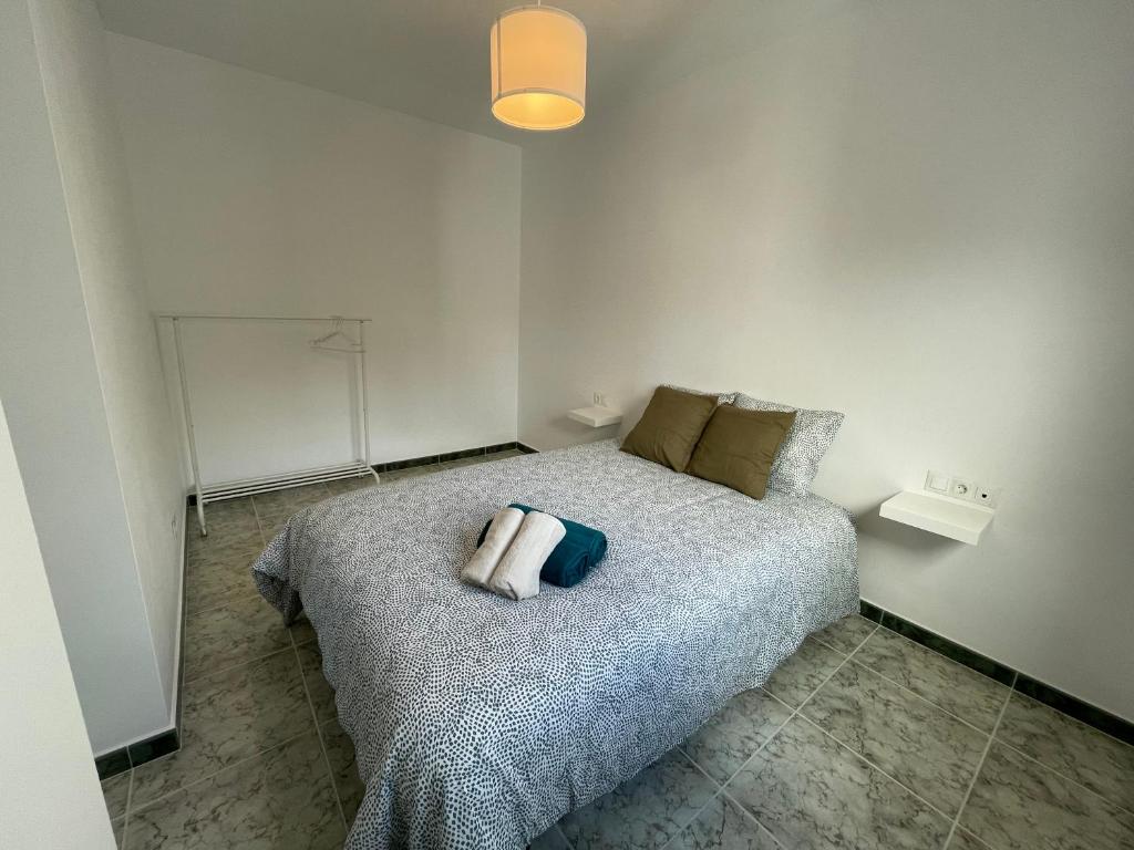 1 dormitorio con cama con almohada en Apartamentos Los Senderos de Tolox en Tolox