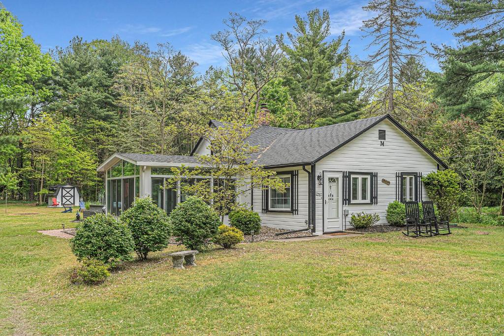 a small white house with a yard at Tower Hill Cottage in Sawyer
