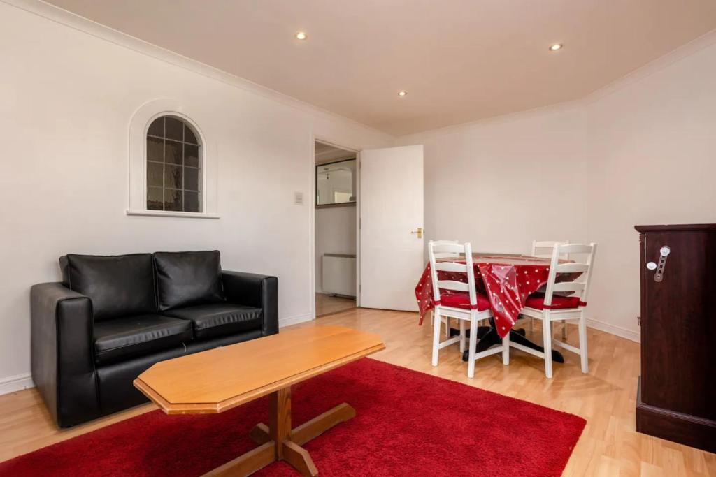 ein Wohnzimmer mit einem Sofa und einem Tisch in der Unterkunft Stylish 2 Bedroom Apartment near the City Centre in Edinburgh