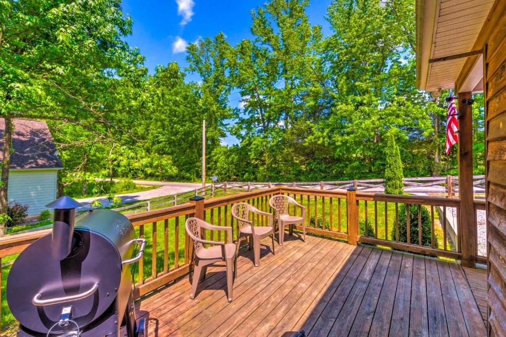 a wooden deck with chairs and a grill on it at Country Cottage Less Than 3 Mi to Dale Hollow Lake! in Byrdstown