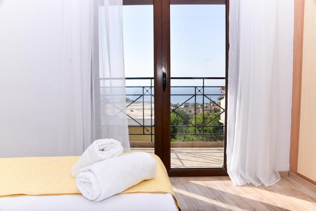 a room with a bed and a window with towels at Prana's Castle in Kyparissia