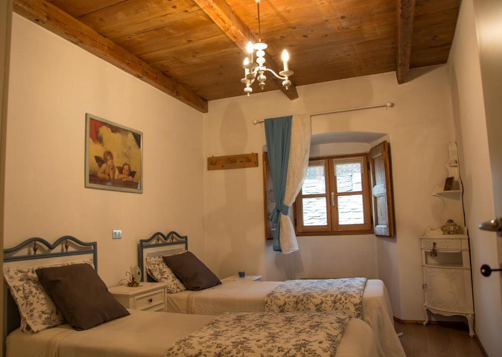 a bedroom with two beds and a window at bb chiavenna centro storico in Chiavenna