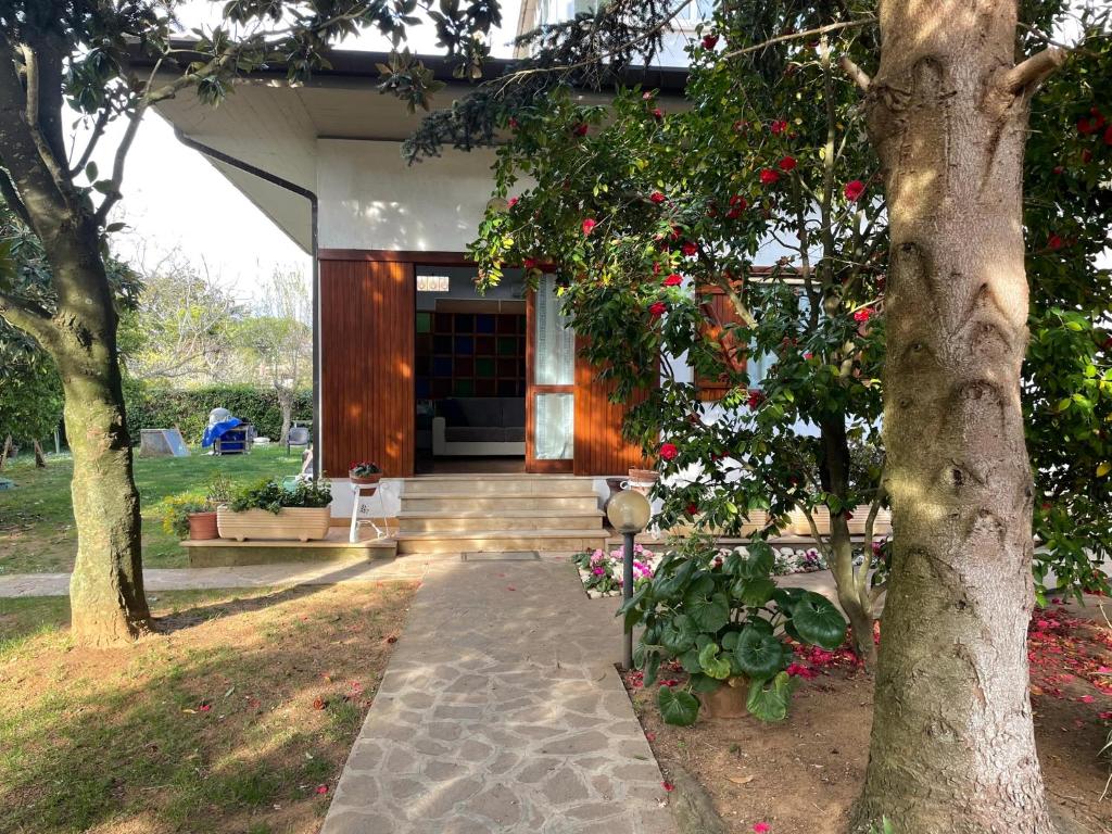 a house with a porch with flowers in front of it at Appartamento in Villa con giardino vicino al mare in Bella Farnia