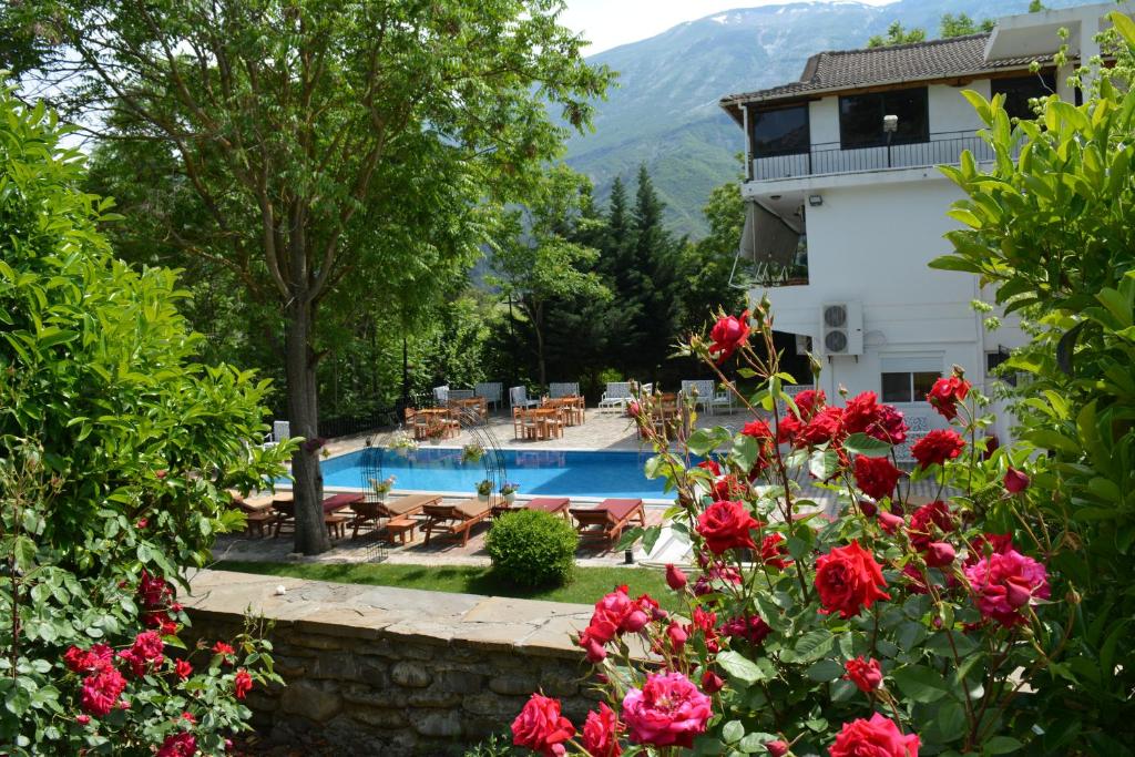 a resort with a swimming pool and flowers at Hotel&Restaurant Aroma in Përmet
