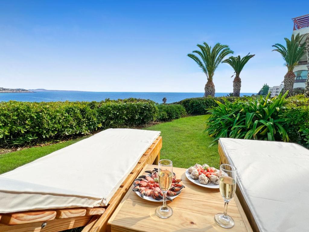 - une table avec deux assiettes de nourriture et des verres de vin dans l'établissement Puerto Velero Primera Línea Primer Piso con Jardín, Piscina y Playa! 7pax, à Puerto Velero