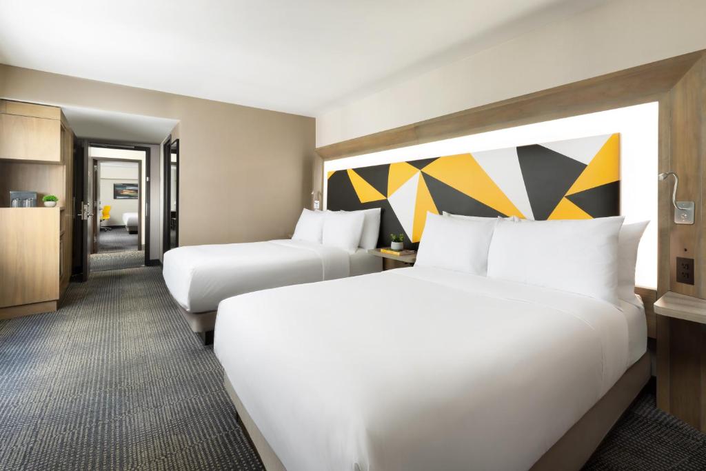 a hotel room with two beds and a kitchen at M Social Hotel Times Square New York in New York