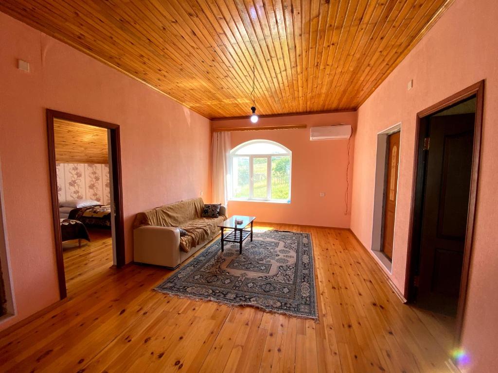 uma sala de estar com um sofá e uma mesa em La Casa de Habel em Quba