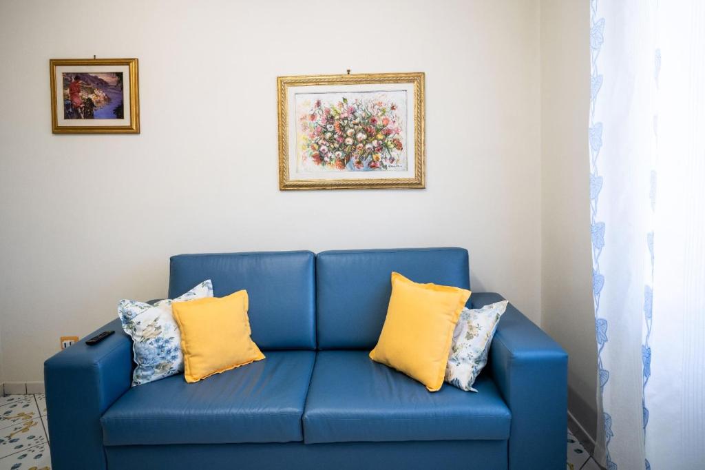 ein blaues Sofa mit gelben Kissen in einem Zimmer in der Unterkunft Casa Vacanza La Gardenia in Tramonti