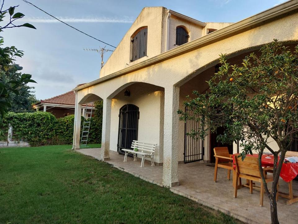 a house with a bench and a table in the yard at Villa Anesis-Παραθαλάσσια βίλα in Amalias