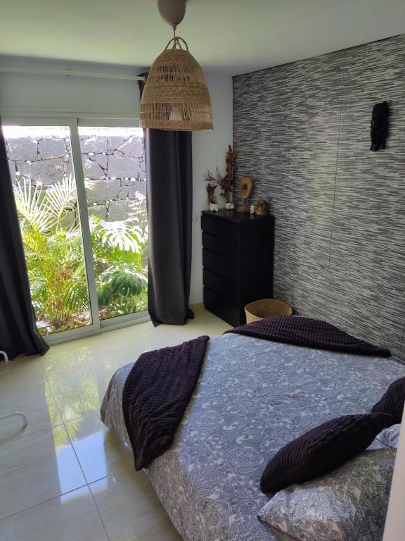 sypialnia z łóżkiem i dużym oknem w obiekcie Love for Lanzarote holidays house w mieście Playa Blanca