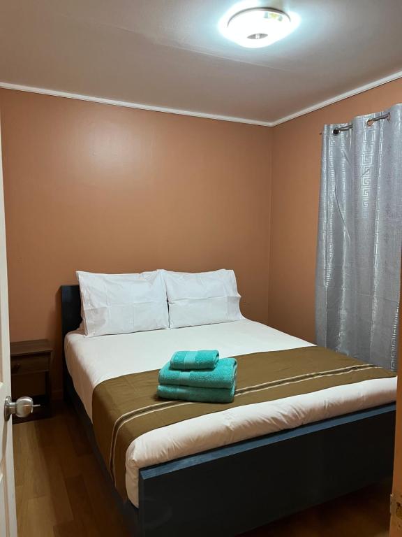Un dormitorio con una cama con una toalla verde. en Cabañas Caur, en San Pedro de Atacama