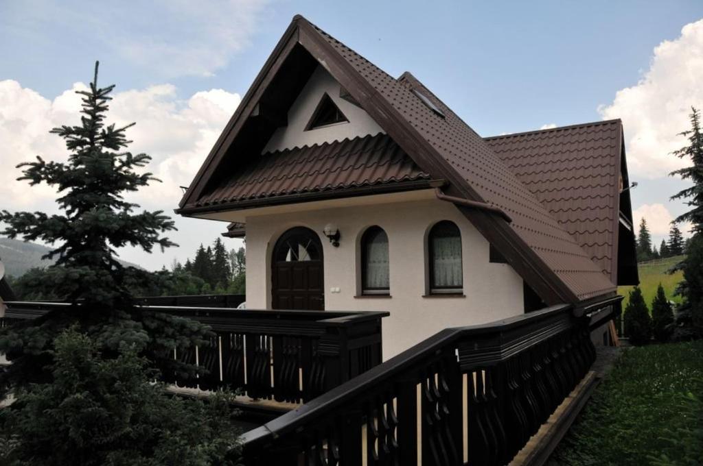 ザコパネにあるDomek Bączekの茶色の屋根の小さな白い家