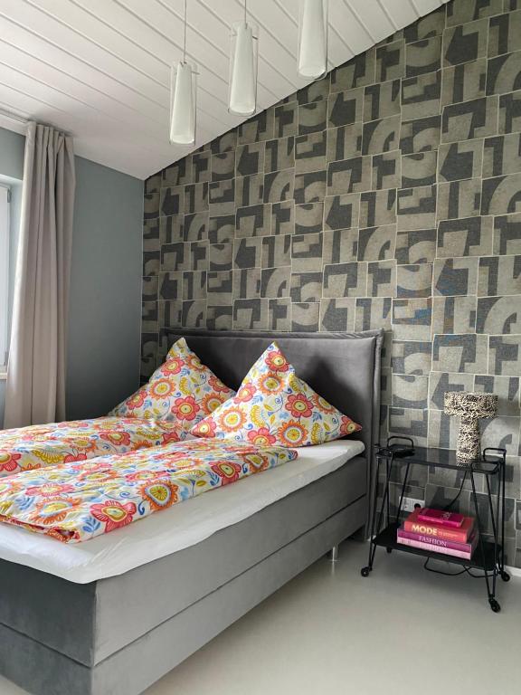 a bedroom with a bed with colorful sheets and a wall at Petit Appartement in Hapberg