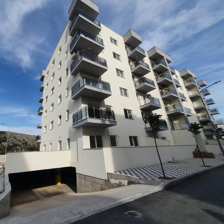 a tall white building with balconies on it at Gimi Apartments Shengjin in Shëngjin